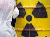 Man in protective clothing in front of a barrel of radioactive material (photo: dpa)